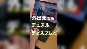 ノートパソコンの画面を左右に2分割し、手前でキーボードを操作している様子。画面上には「外出先でもデュアルディスプレイ」というテキストが表示されています。