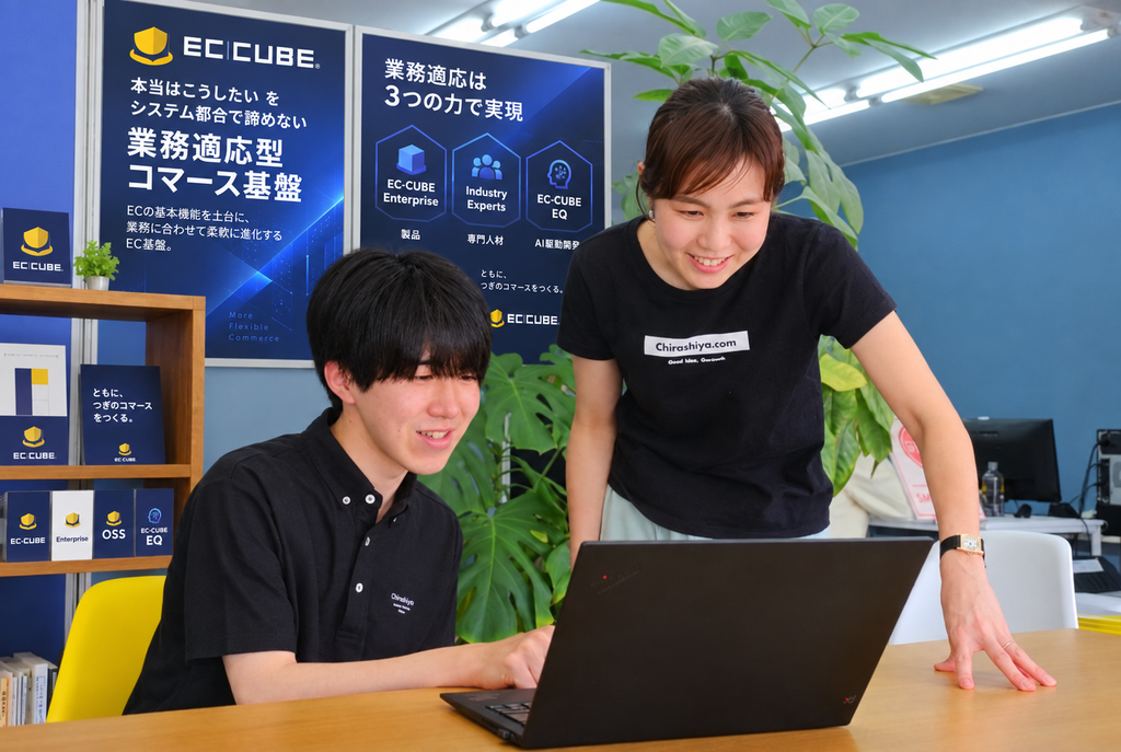 当社スタッフの打合せ風景(背景にはECCUBEのポスターイメージ)