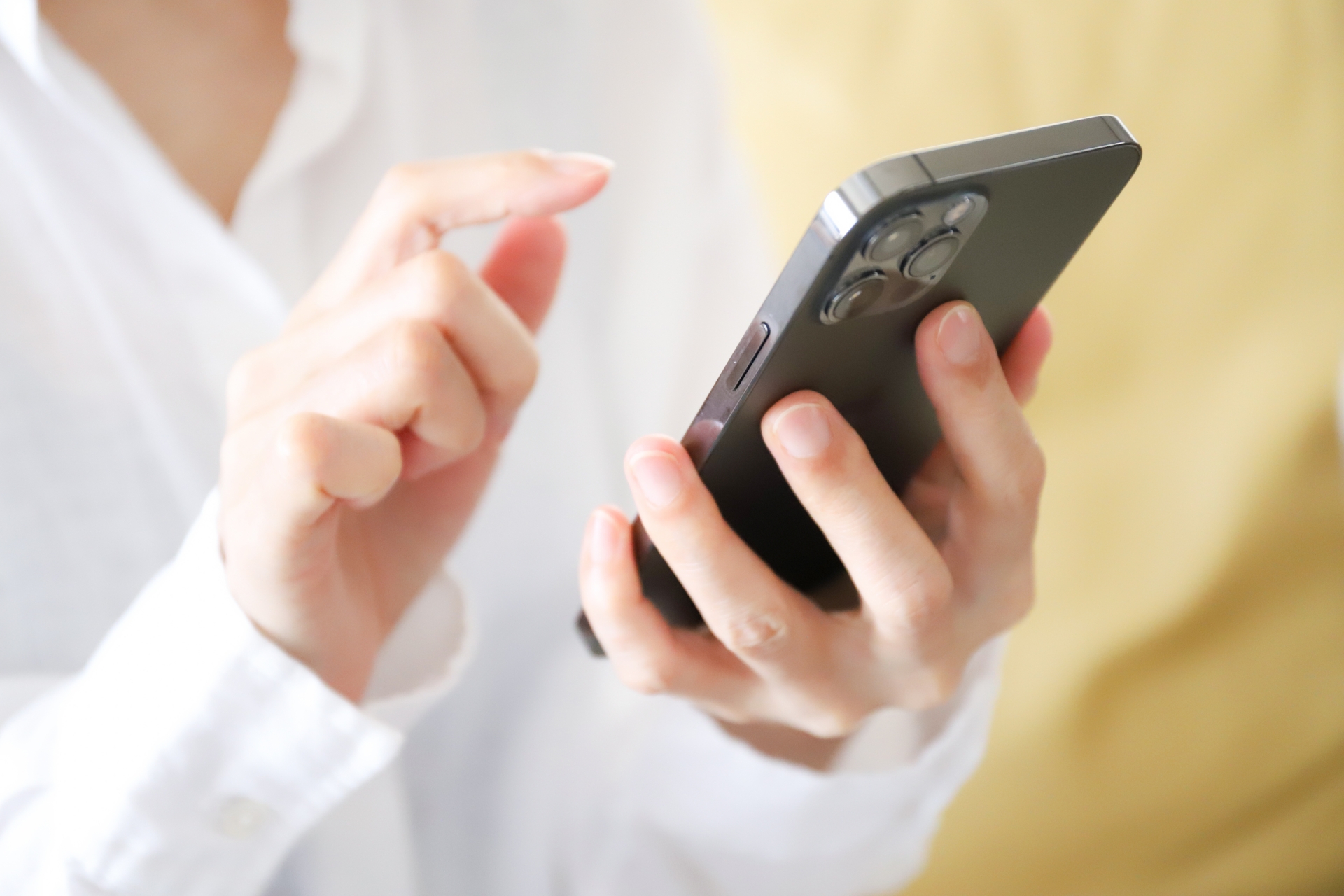 スマートフォンを操作する手元