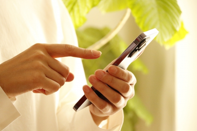 女性がスマホを持っている写真